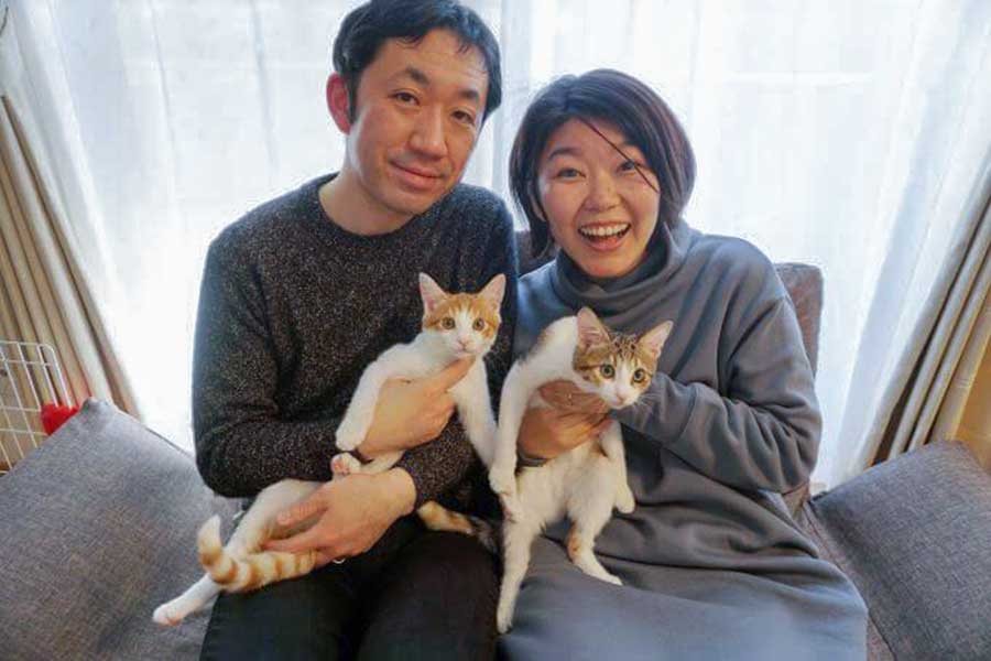 飼い主さんご夫婦に抱っこされるツナくん（左）とマヨちゃん【写真提供：猫のツナとマヨ TunaMayo Cats（@tunamayo_cats）さん】