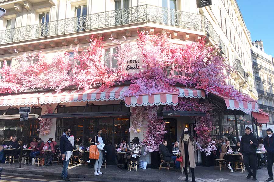 ピンクの花で彩られたパリ市内のカフェ。花の空間演出は生活の身近な場にも【写真：小川由紀子】