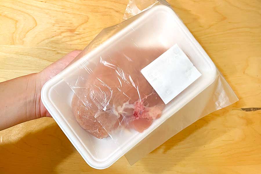 冷蔵されていた肉のパックの上にポリ袋を置く【写真：Hint-Pot編集部】
