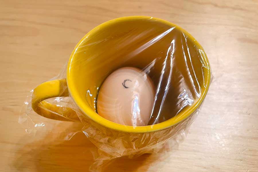 マグカップにゆで卵と水を入れ、ラップをかける【写真：Hint-Pot編集部】
