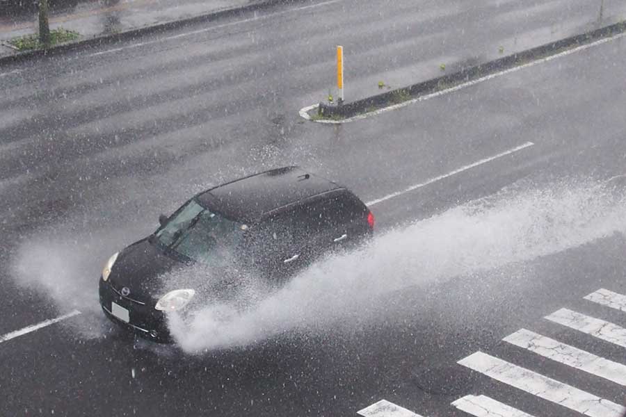水しぶきを上げて車道を走行する車（写真はイメージ）【写真：写真AC】