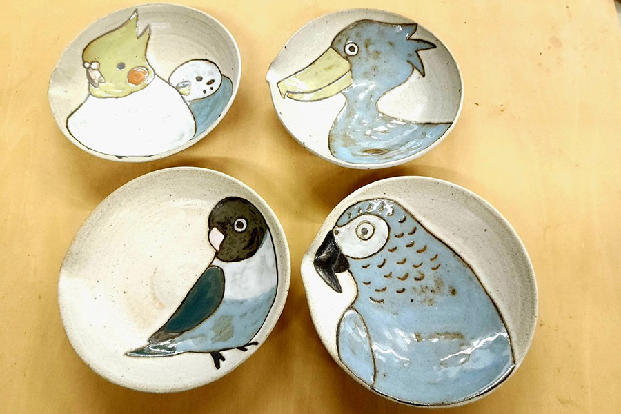 鳥をモチーフにした器。（左上から時計回りに）優しい色合いで描かれたオカメインコとセキセイインコ、ハシビロコウ、ヨウム、ボタンインコが素敵！【写真提供：陶房呑器（@hisaejinnohara）さん】