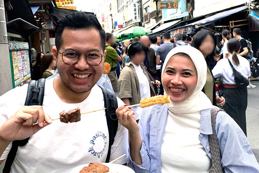 （左から）築地場外市場で食べ歩きを楽しむインドネシア人のリトさんとプットリーさん【写真：Hint-Pot編集部】