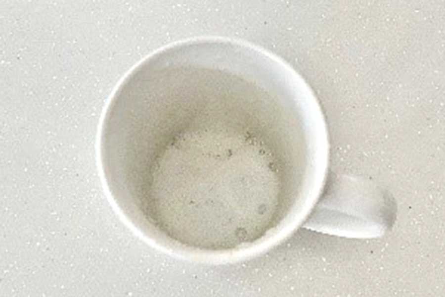 着色汚れのあるマグカップにキッチン用漂白剤を入れて浸け置きする【写真：Hint-Pot編集部】