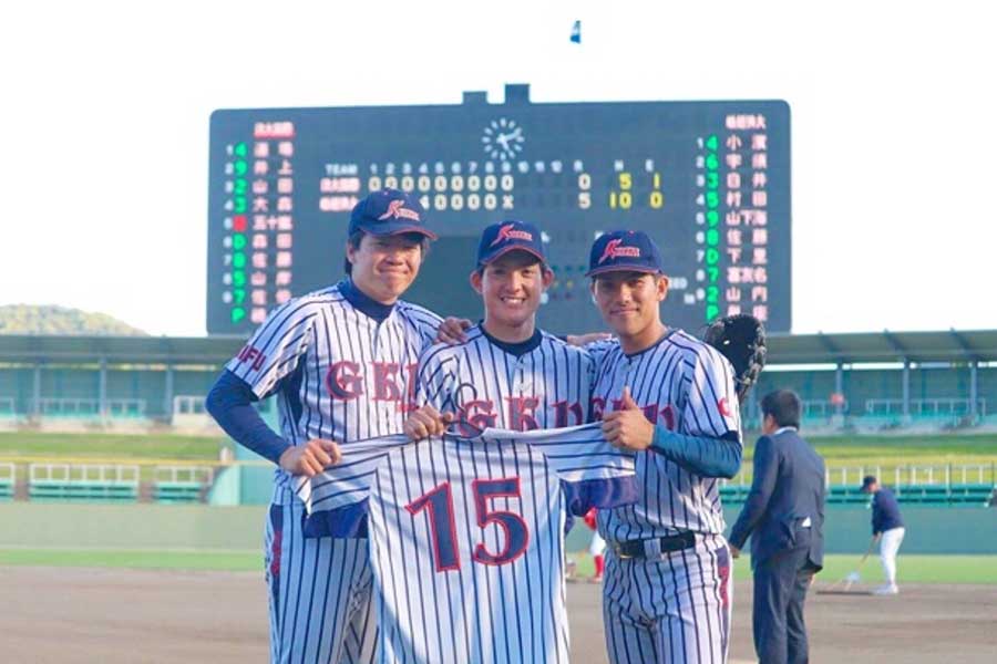 大学時代の盟友・中野さんの背番号15のユニフォームを手にする與座選手（中央）【写真提供：與座海人】
