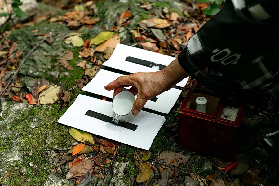 祈りが身近にある、やんばる集落の拝所で祈る人の様子【写真提供:やんばるホテル南溟森室】