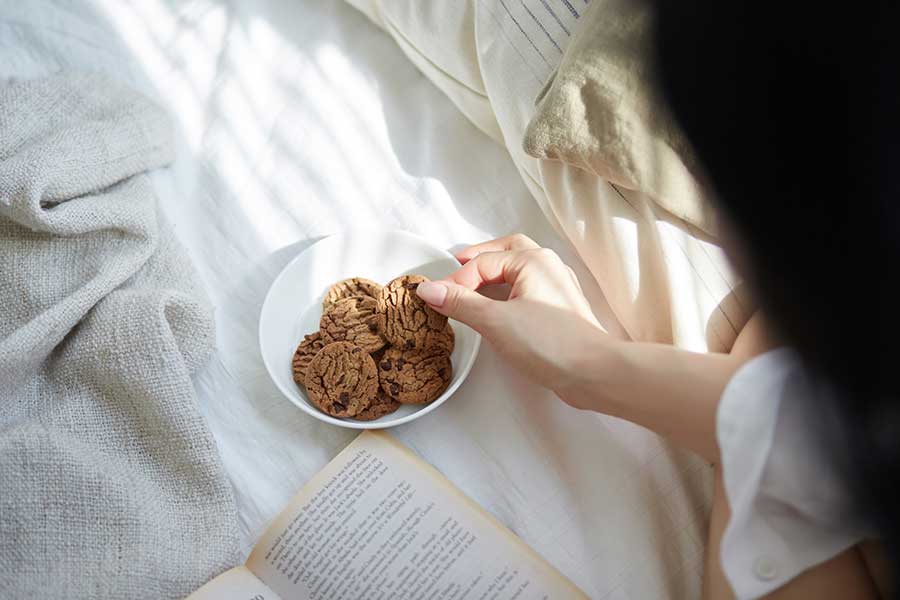 ベッドの上での飲食は控え、「軽食やドリンクはできればデスクで！」と呼びかけ（写真はイメージ）【写真：PIXTA】
