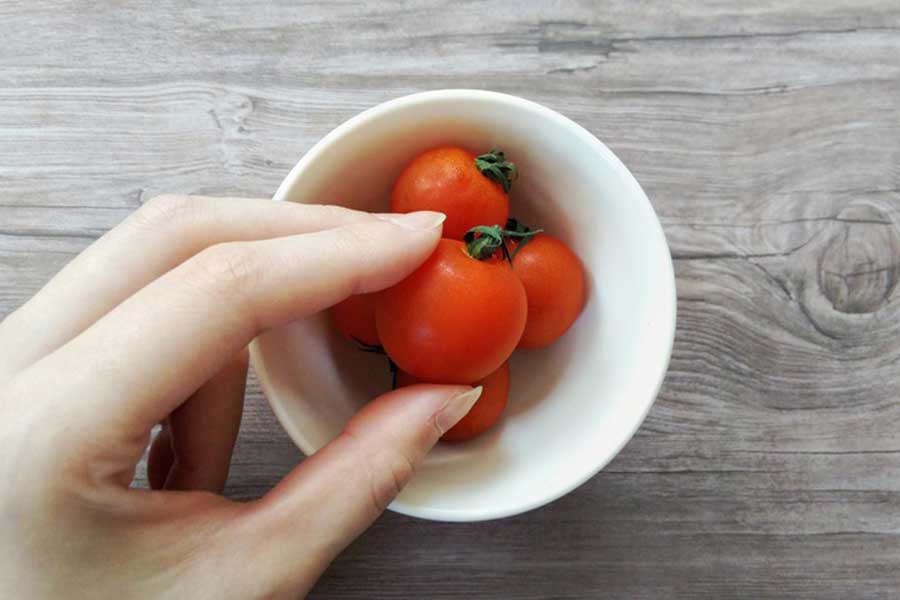 ミニトマトはヘタ周りのくぼみに細菌が残っている可能性があるため、ヘタ付きのままお弁当に入れるのはNG。ヘタを取ってから水洗いして、切らずに丸ごと入れよう（写真はイメージ）【写真：写真AC】