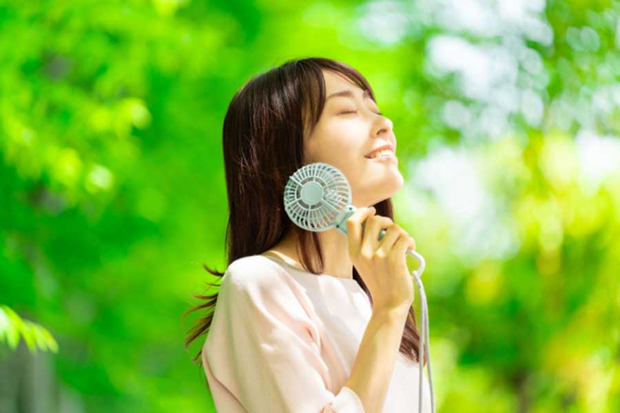 ハンディファンで涼む女性（写真はイメージ）【写真：写真AC】
