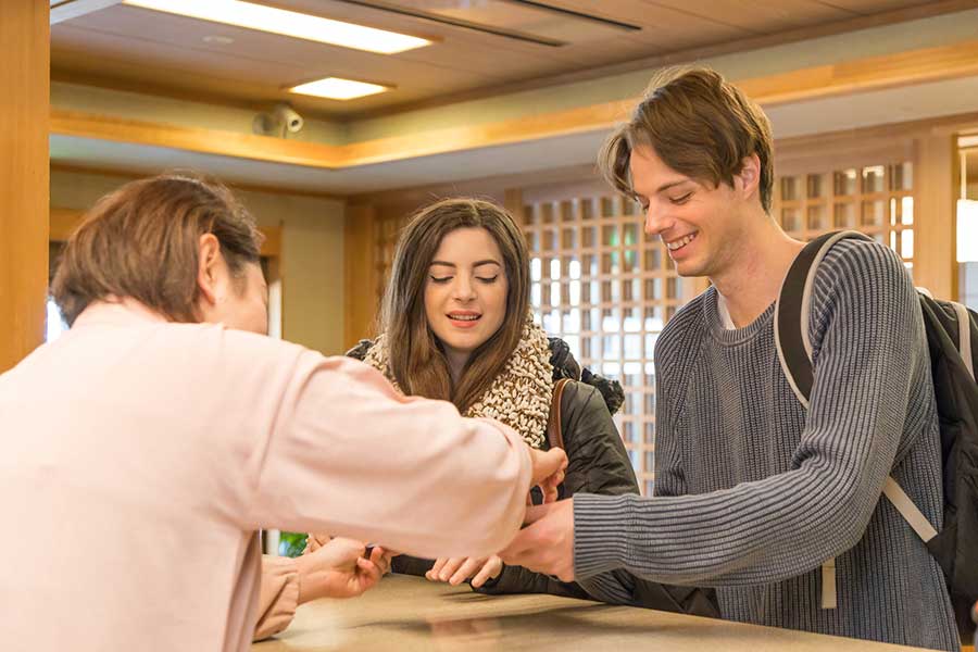 チェックインする外国人に、丁寧に説明するホテルスタッフ（写真はイメージ）【写真：PIXTA】