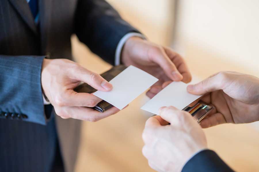両手で行う名刺交換（写真はイメージ）【写真：PIXTA】
