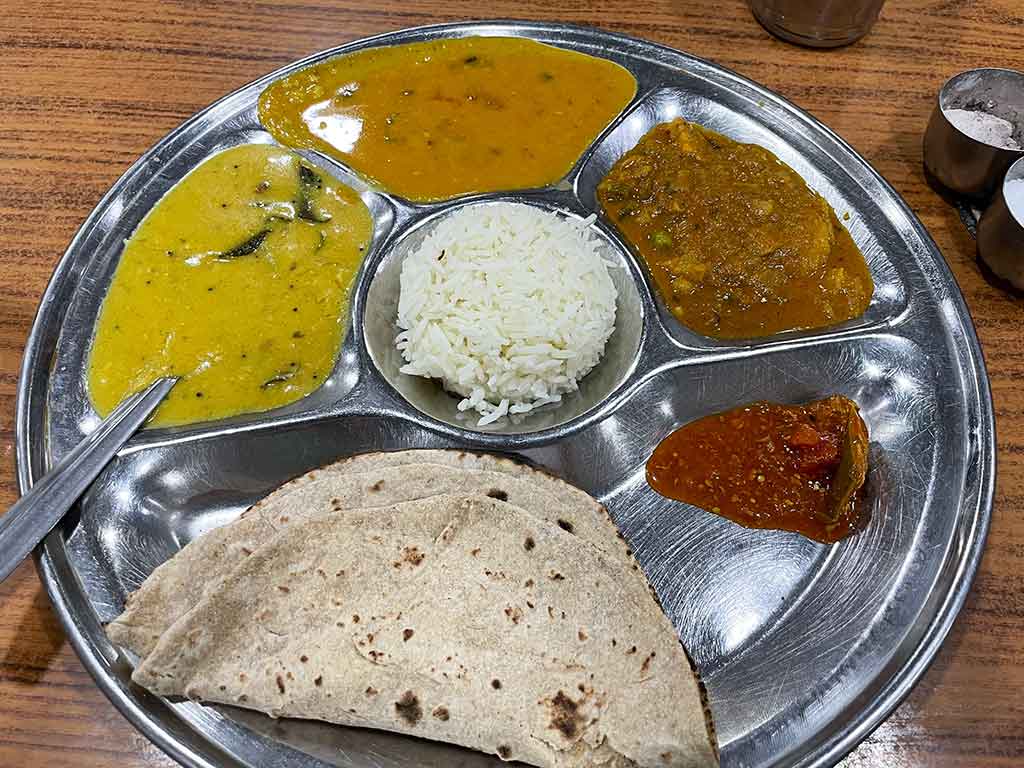 チャパティ（下）とおかずがのったターリー（定食）。全粒粉の優しい甘みが感じられるため、筆者はナンよりチャパティが断然好き【写真：中谷秋絵】