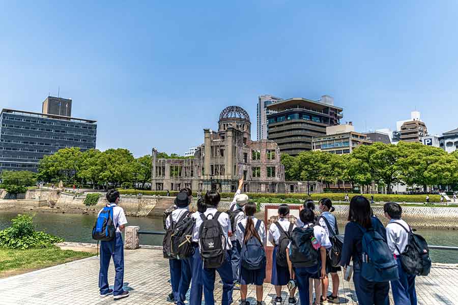 「自由や平和への考え方」が似ているとミヒャエルさん。原爆ドームを前にボランティアガイドの説明に聞き入る人々（写真はイメージ）【写真：PIXTA】