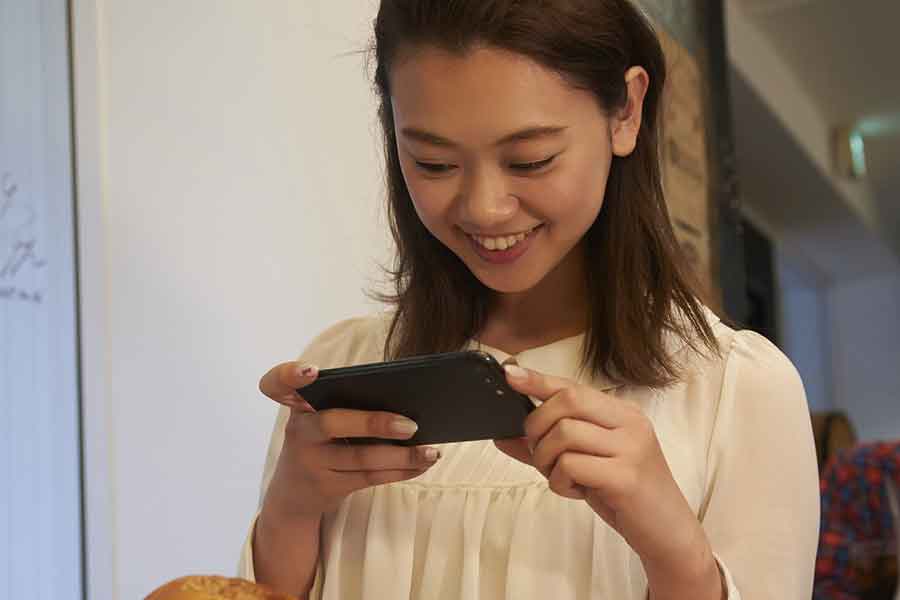 スマホの操作に夢中で提供された料理をすぐに食べない（写真はイメージ）【写真：PIXTA】