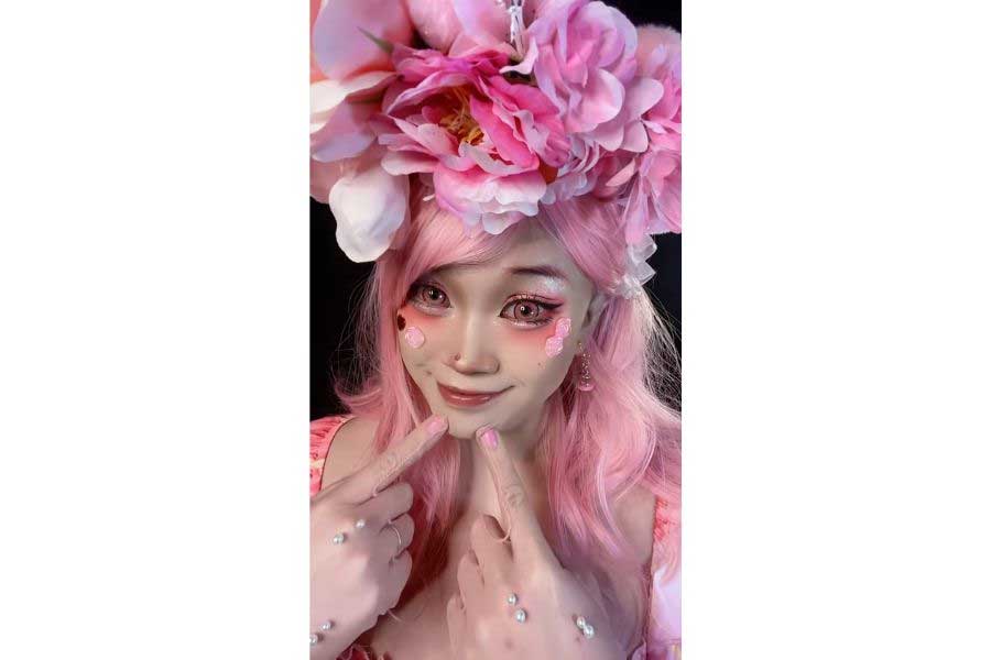 ピンク一色の衣装とウィッグに身を包み、愛くるしい表情(スクリーンショット)