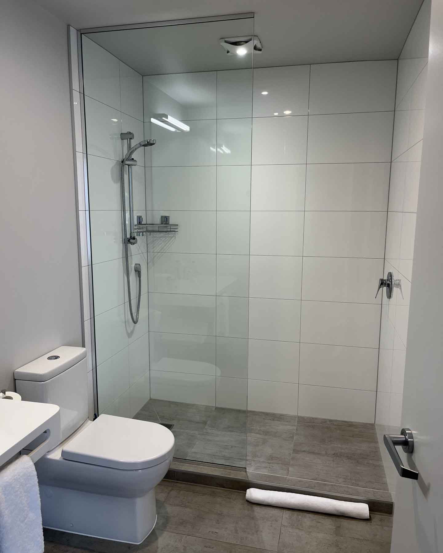 透明な壁で半分だけ仕切られた、海外ホテルのシャワールーム。隣のフロアに水が流れやすい構造（写真はイメージ）【写真：写真AC】