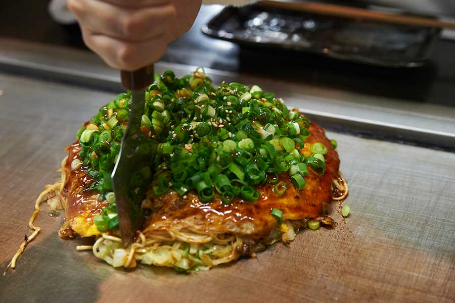 野菜や肉など具だくさんで、目の前で調理してもらえるお好み焼き（写真はイメージ）【写真：PIXTA】