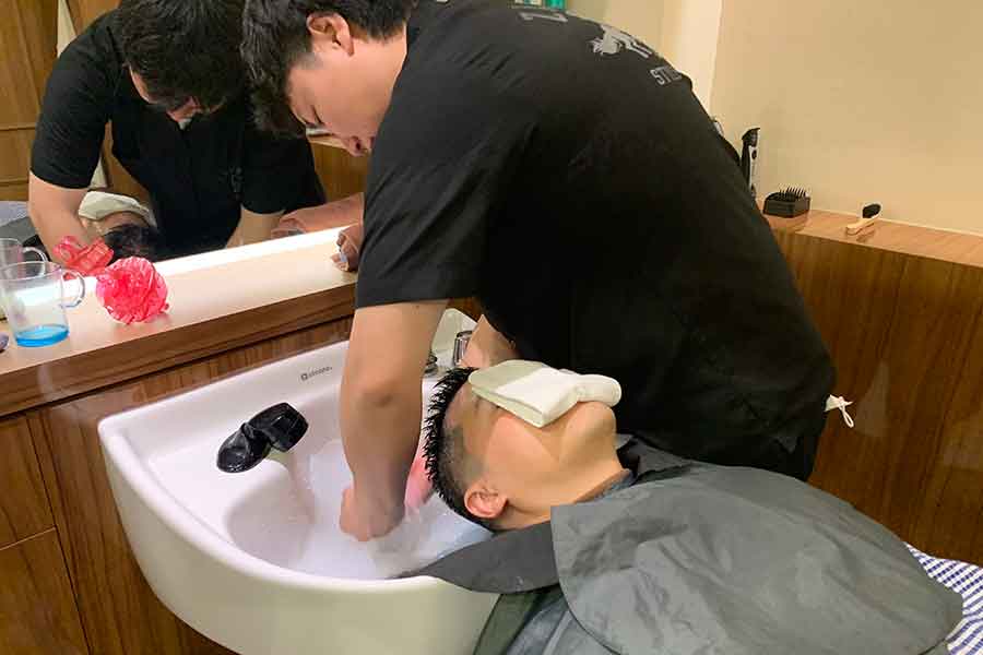 理容室で洗髪サービスを受けるシュテファンさん【写真：Hint-Pot編集部】