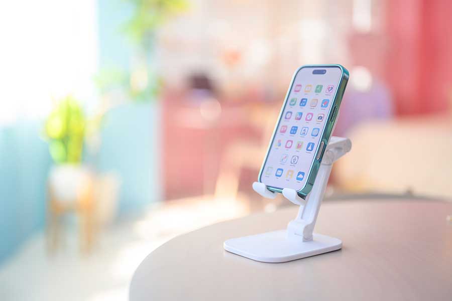 スマホスタンドを活用するなど、できるだけスマホと目線の高さを合わせることが大切（写真はイメージ）【写真：PIXTA】