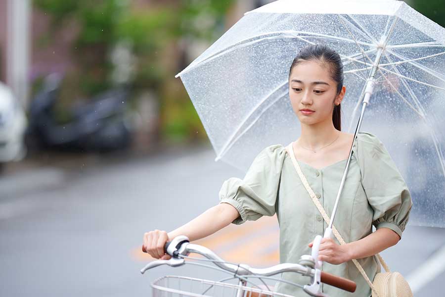 「傘差し運転」はNG。自転車を押す女性(写真はイメージ)【写真:写真AC】