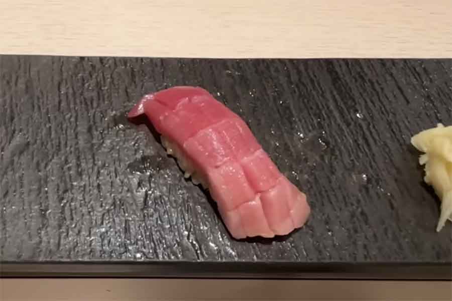 ちょうどいい量のしょうゆが塗られた中トロの握り【出典：YouTube「日本食冒険記Tokyo Food Adventures」よりスクリーンショット】