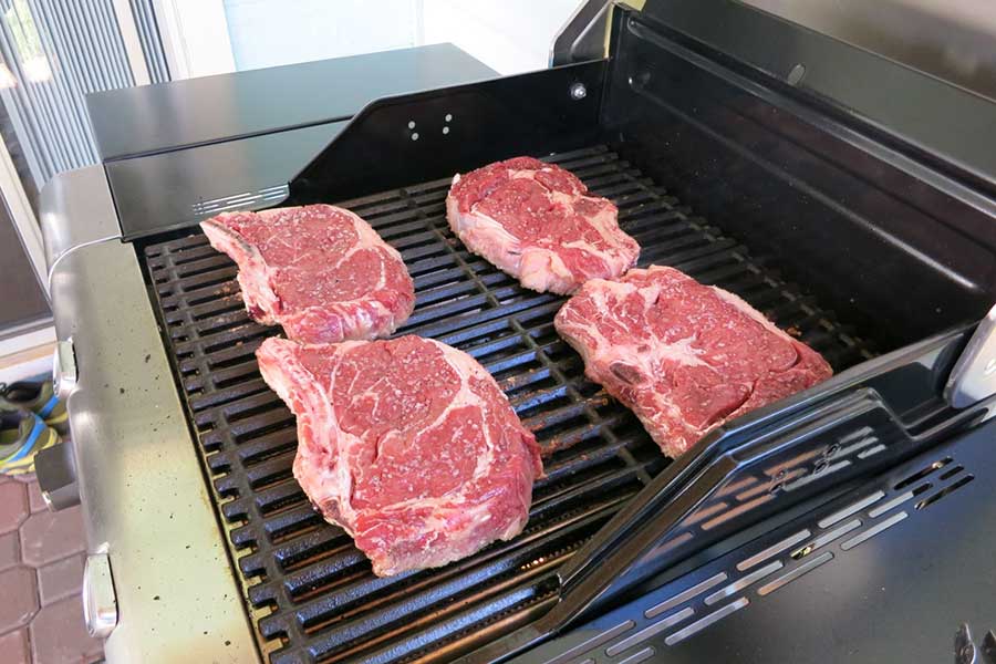 自宅の庭先にて、バーベキューグリルでステーキ肉を焼いているところ【写真:i-know】