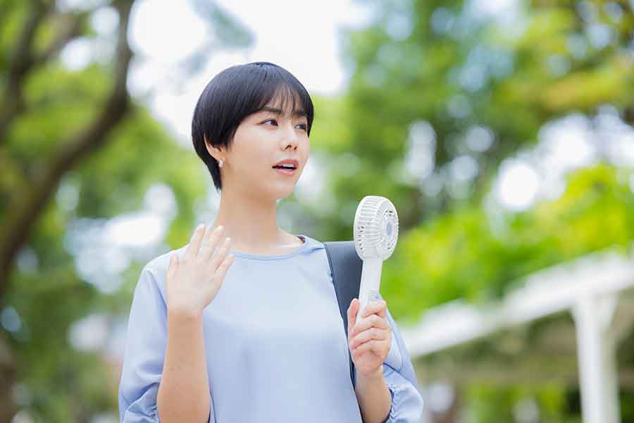 ハンディファンを使う日本人女性（写真はイメージ）【写真：PIXTA】