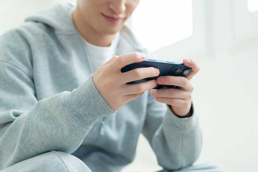 子どものデジタル依存が社会問題になるなか、画面に夢中になる若者（写真はイメージ）【写真：PIXTA】