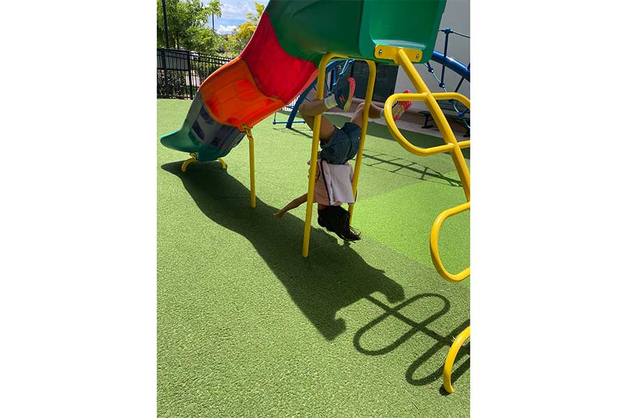 人工芝の床材が敷かれた公園の遊具で遊ぶ娘。ハワイでは公園によって足元の環境もさまざま【写真:i-know】