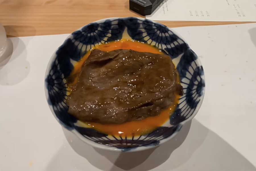 生卵とともに提供されたすき焼き【出典：YouTube「日本食冒険記Tokyo Food Adventures」よりスクリーンショット】