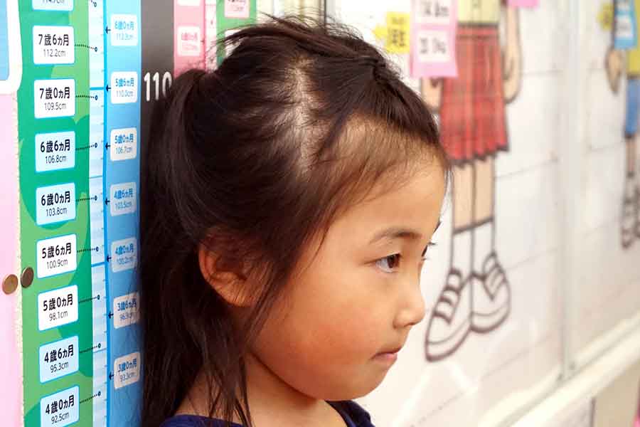 身長を測る子ども（写真はイメージ）【写真：写真AC】