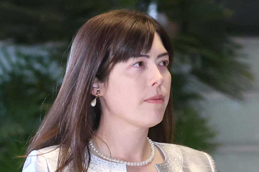 シルバーのドレス姿で、認証式を前に首相官邸に入る小野田紀美経済安保相(2025年10月21日)【写真:産経新聞社】