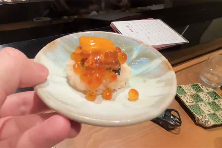 イクラ寿司の上に乗せられたウニに驚き【出典：YouTube「日本食冒険記Tokyo Food Adventures」よりスクリーンショット】